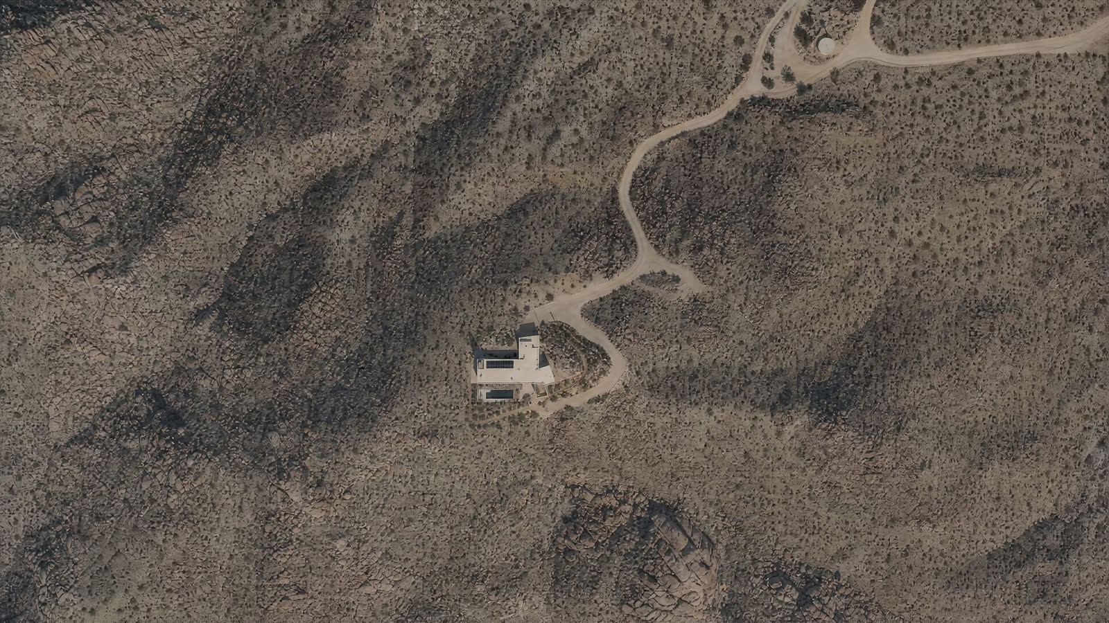 Twelve minutes off the highway, one pale rectangle on the alluvial fan. Everything else is creosote, rock, and the road that gave up.